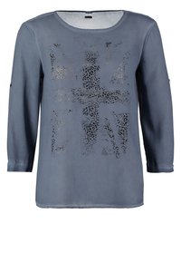 Chemise grise à manches longues avec un col rond et un motif discret imprimé léopard noir en forme de drapeau Union Jack sur le devant.