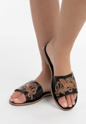 Infradito in pelle nera con intricate ricami floreali in tonalità tan, design aperto sulla punta, suola piatta e texture liscia.