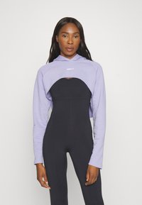 Felpa cropped viola sopra un body nero. La felpa presenta un cordino, mentre il body ha un design aderente e un colletto rotondo.