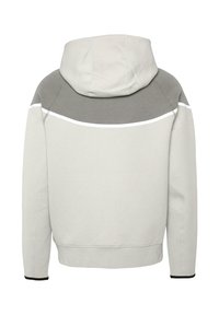 Sudadera gris claro con un panel superior de gris más oscuro. Cuenta con un capucha con cordón, acentos blancos y puños de canalé. Textura suave.