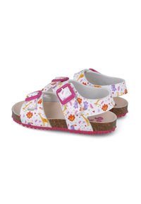 Sandalias infantiles multicolor con un patrón floral, material superior blanco, hebillas rosas y una suela de corcho marrón con pisada rosa.