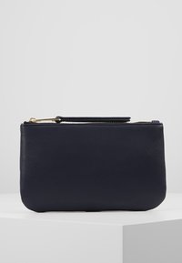 Pochette en cuir marine avec une texture lisse et une fermeture éclair dorée. Forme rectangulaire compacte, dotée d'une petite poignée pour un transport facile.