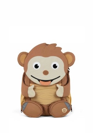 Brown monkey-shaped children's backpack with big eyes, sticking out tongue, beige hands and feet, and front mesh pocket.
