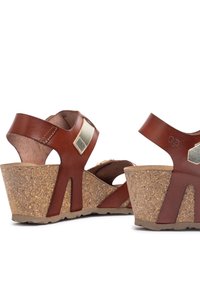 Bruine leren wedge sandalen met kurken zolen, voorzien van goudkleurige accenten, verstelbare bandjes en een open teen ontwerp.