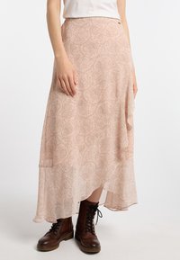 Flot, lyserød nederdel med intrikate paisley-mønstre, letvægtsstof, asymmetrisk kant, parret med brune snørebåndsstøvler.
