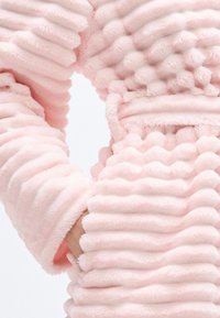 Halat roz din blană artificială cu textură nervurată, având rânduri groase și pufoase și o talie cu curea pentru un plus de design.