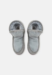 Zapatillas de ante gris con forro suave y esponjoso. Diseño con puño plegable, detalles trenzados a lo largo del borde superior y suelas planas duraderas.