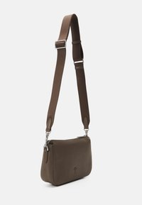 Borsa a tracolla in pelle marrone con texture liscia, dotata di chiusura con zip, tracolla in tessuto regolabile e dettaglio logo discreto sulla parte anteriore.