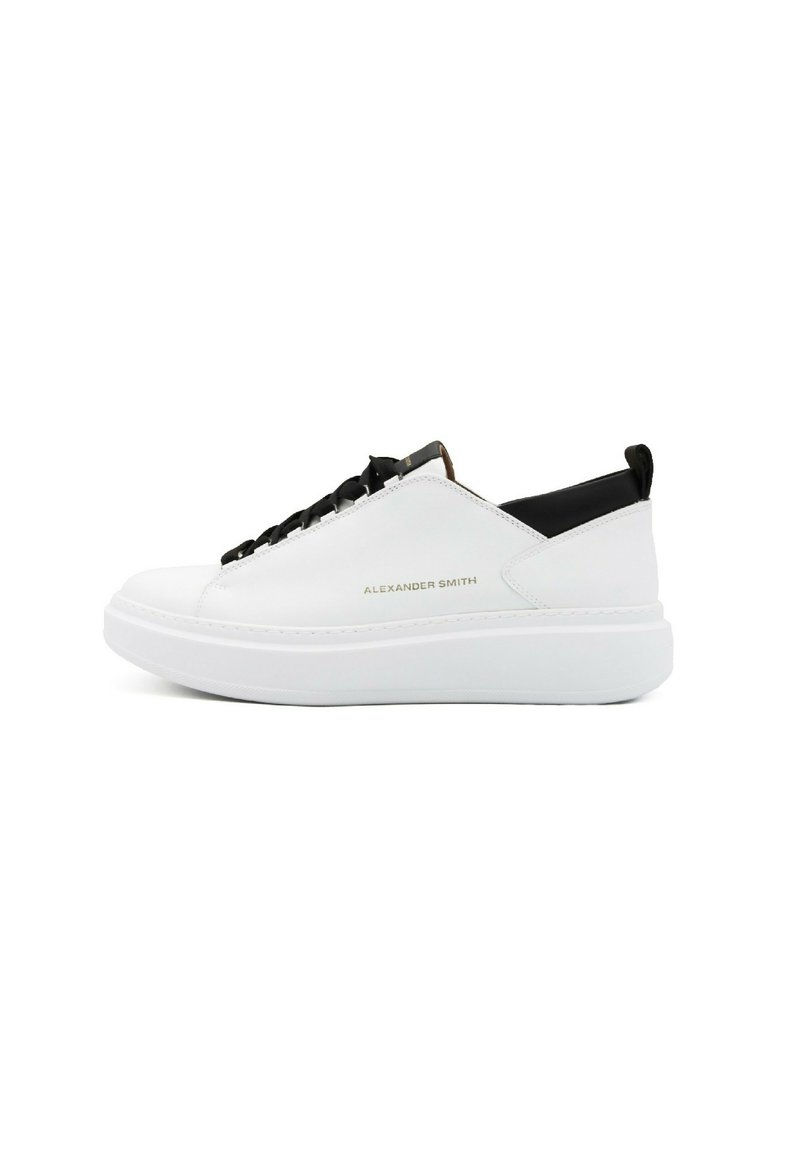 Sneakers bianchi in pelle a bassa altezza con un tallone testurizzato nero, lacci neri, suola elevata bianca e branding in rilievo sul lato.