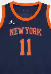 Temno modra košarkarska majica z oranžnimi detajli, z napisom "NEW YORK" v odebeljenih črkah in številko "11" v svetlo oranžni barvi z modrim obrobo.