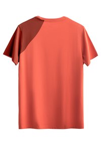 Koraalkleurig T-shirt met korte mouwen, met een contrasterend donkeroranje paneel op de linkerschouder, ronde hals en zachte textuur.