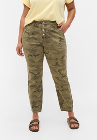 Kalhoty s maskáčovým potiskem v olivově zelené barvě se zvýšeným pasem, uzávěrem na pět knoflíků a bočními kapsami. Tkanina vypadá pevně a má hladkou texturu.