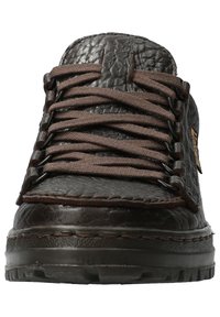 Sneaker en cuir marron avec finition texturée, doté de lacets marron et d'une semelle en caoutchouc noire. Détail de couture notable le long du bord.