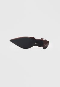 Zapato de tacón alto marrón con punta afilada, tira trasera y suela texturizada negra. El zapato presenta un acabado mate y un diseño minimalista.