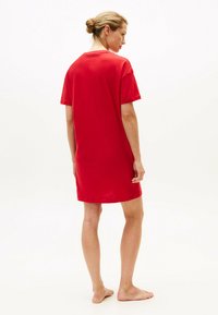 Rotes Baumwoll-T-Shirt-Kleid mit kurzen Ärmeln, rundem Ausschnitt und lässiger Passform. Glatte Textur in einfarbigem Design, ohne Muster oder Akzente.