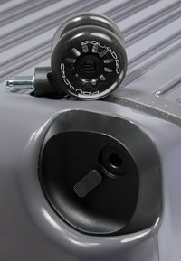 Schwarzes Rad mit transparenten Kanten, montiert an einem grauen Koffer. Verfügt über eine Metallbefestigung und ein schwarzes Gehäuse mit strukturierter Griffoberfläche.