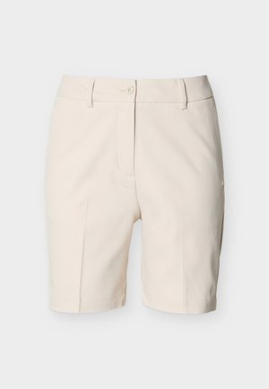 Bézs, testhez szabott térd hosszúságú rövidnadrág gombos záródással, övbújtatókkal és finom varrási részletekkel, egyszínű háttéren.