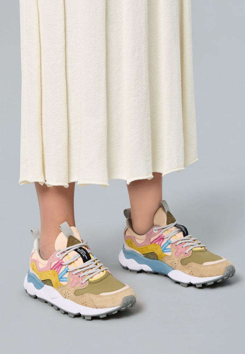 Sneaker multicolori con un mix di materiali beige, rosa, verde e blu, con pannelli in suede testurizzati e mesh, e una suola bianca voluminosa.