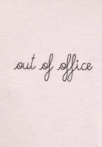 Bílá tkanina s černým kurzivním vyšívaným textem "mimo kancelář." Design má jemnou texturu a jednoduchý styl písma.