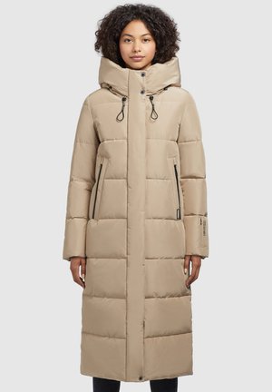Beige long puffer coat with a high collar, quilted texture, zippered side pockets, adjustable drawstrings, and logo accent on the sleeve.