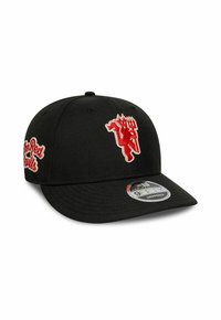 Casquette snapback basse noire avec logo de diable rouge à l'avant et texte "The Red Devils" rouge sur le côté. Autocollant sur la visière avec la marque "9FIFTY".