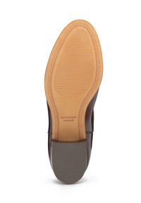 Skórzana podeszwa buta o gładkim beżowym wykończeniu, z żłobionym wzorem zapewniającym przyczepność. Nazwa marki "WITTCHEN handmade" nadrukowana w pobliżu pięty.