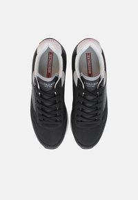 Fekete hálós sportcipők textúrált felülettel, szürke díszítéssel, fűzős dizájnnal és párnázott nyakkal a kényelemért. A logó a nyelven látható.