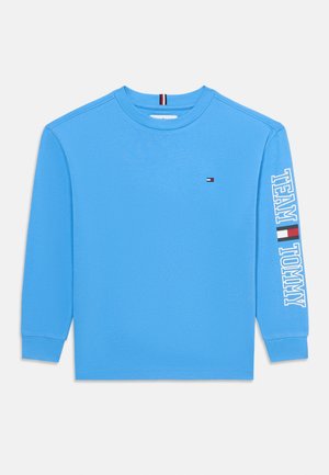 Langærmet blå crewneck-trøje med lille Tommy Hilfiger-flag på brystet og teksten "TEAM TOMMY" med flag på højre ærme.