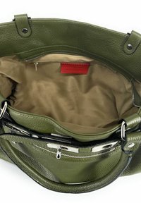 Sac à main en cuir vert avec intérieur en tissu beige, poche zippée en argent et étiquette rouge à l'intérieur.