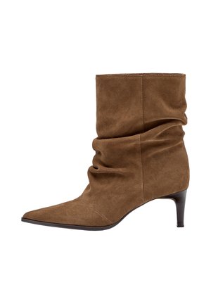 Ruskea mokkanahkainen keskipitkä saapas, jossa on laskostettu varsi, terävä kärki ja hoikka keskikorkea korko valkoisella taustalla.