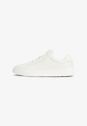 Zapatillas de cuero texturizado blancas con suela de goma, punta redonda y cierre de cordones. El diseño presenta acentos minimalistas y bordes suaves.