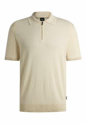 Beige short-sleeve polo shirt with a zippered neckline, ribbed cuffs, and hem, featuring subtle contrasting stitching details.