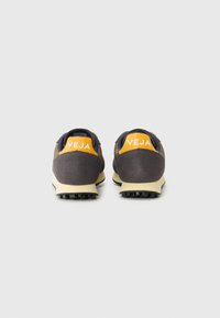 Sneaker grigi con tomaia in suede e rete. Accento giallo sul tallone con il logo "VEJA". Suola in gomma nera con motivo antiscivolo.