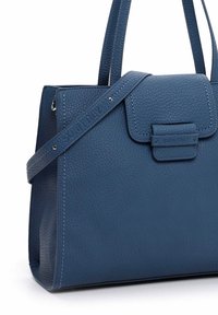 Sac à main en cuir bleu texturé avec deux poignées et une bandoulière réglable embossée du nom de la marque "SURI FREY."