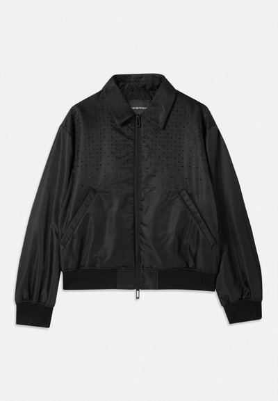 Black bomber jacket with a zip closure, featuring a smooth satin finish, side pockets, and a dotted pattern on the front. Ribbed cuffs and hem.