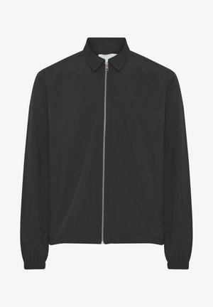 Fekete, könnyű dzseki galléros nyakkal, teljes hosszúságú cipzárral és rugalmas mandzsettákkal. Sima textúra, látható minták vagy díszítések nélkül.