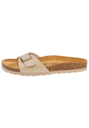 Beige slide sandal with a glossy finish, adjustable strap featuring a metallic buckle, cork sole, and soft footbed for comfort.