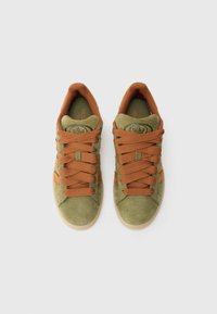 Ténis de camurça verde com atacadores e detalhes castanhos, apresentando biqueira redonda e superfície texturizada. Logótipo em relevo na língua.