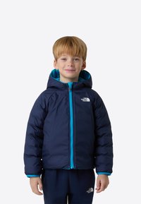 Μπουφάν σε σκούρο μπλε χρώμα με εσωτερική φόδρα τιρκουάζ, εμπρόσθιο φερμουάρ και κουκούλα. Το ύφασμα φαίνεται ομαλό και μονωμένο.