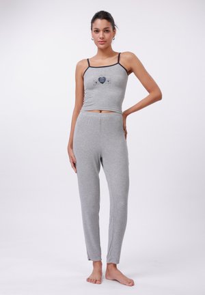 Grå pyjamas-set bestående av en åtsittande t-shirt med tunna band och ett hjärt-grafik, i kombination med löst sittande byxor med elastisk midja.
