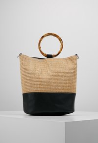 Borsa in paglia intrecciata con base in pelle nera, dotata di un manico in bambù e di una chiusura con zip nella parte superiore per una conservazione sicura.