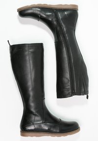 Botas negras de cuero hasta la rodilla con cremalleras laterales, suela de goma plana y detalles cosidos. Textura suave con puntera redondeada.