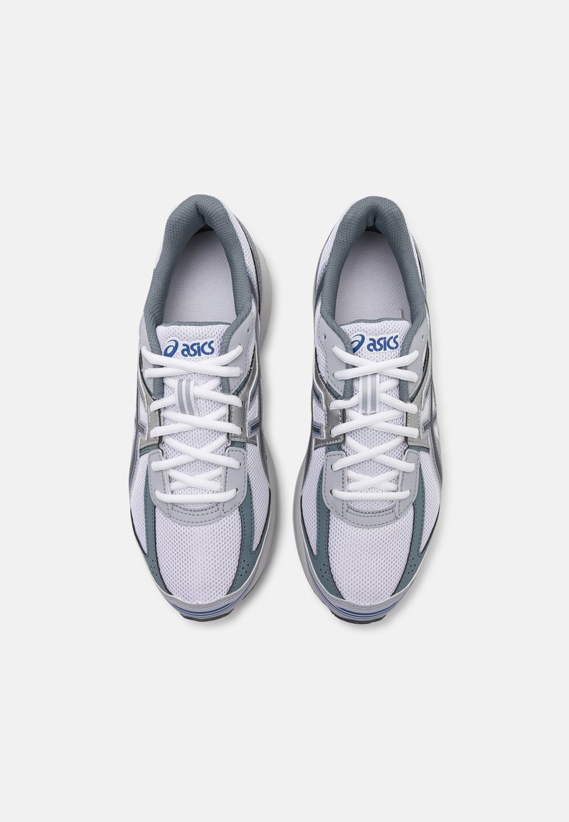 Baskets de sport blanches avec des accents gris, dessus en maille et semelle amortie. Montent avec un laçage et un logo sur la languette. Conception légère.