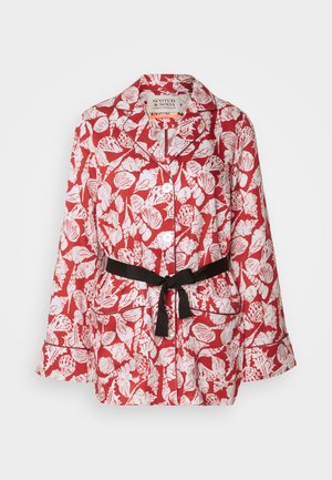 Czerwona kurtka z wzorem w kwiaty i muszle, z białymi motywami, posiadająca czarny pasek, klapy i rozszerzane rękawy.