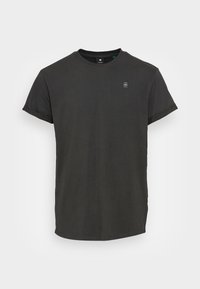 Czarny bawełniany t-shirt z krótkimi rękawami, okrągłym dekoltem i prostym logo na piersi. Gładka tekstura, luźny krój i prosty dół.