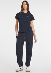 Navy cotton t-shirt with a crew neckline and short sleeves, paired with matching joggers featuring an elastic waistband and cuffed ankles.