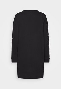 Schwarzes Sweatshirtkleid mit langen Ärmeln, das auf dem rechten Ärmel pinke Textdetails aufweist. Weicher Stoff, gerader Schnitt und Rundhalsausschnitt.