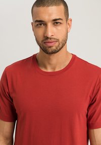 T-shirt in cotone rosso con colletto girocollo e maniche corte. Tessuto liscio e design semplice, adatto per un abbigliamento casual. Nessun motivo o dettaglio particolare.
