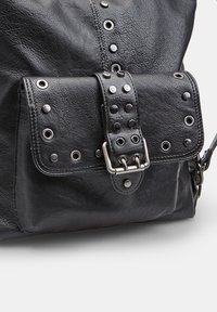 Borsa in pelle nera con finitura testurizzata, chiusura a patta con borchie e accessori in argento, e un distintivo design a cucitura verticale.
