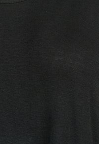 Svart tyg med en jämn textur; har en rund halsringning och saknar synliga mönster eller accenter. Materialet verkar lätt och flexibelt.